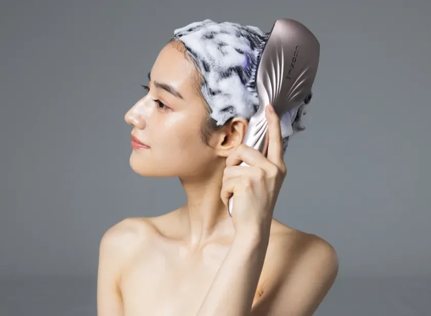 女性が泡立った髪をヘアブラシで洗っている様子