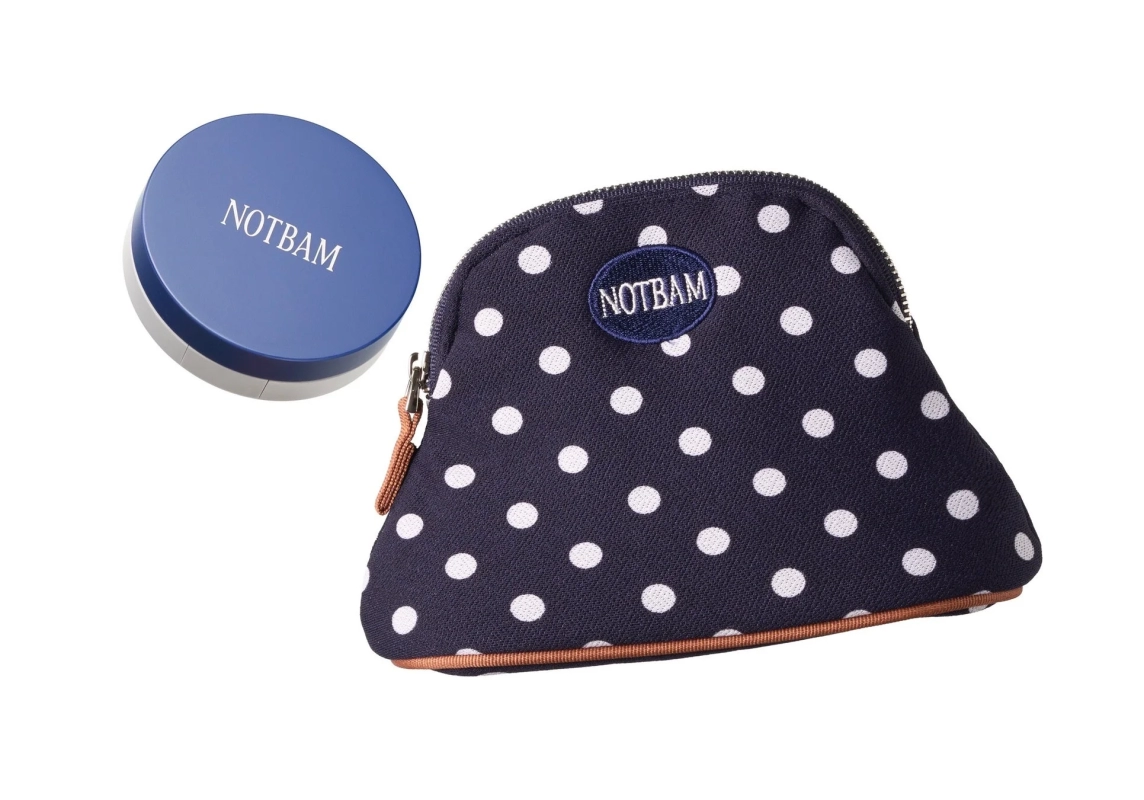青い丸い容器と紺色の水玉模様のポーチが写っています。両方に「NOTBAM」のロゴが見られ、化粧品やファッション小物として使われるアイテムです。