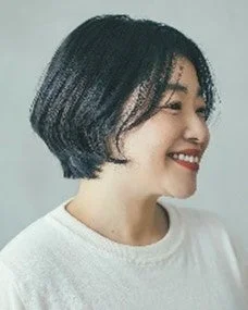 白いトップスを着た黒髪ショートヘアの女性