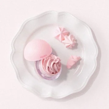 ピンク色の球状容器に入った化粧品とメレンゲ