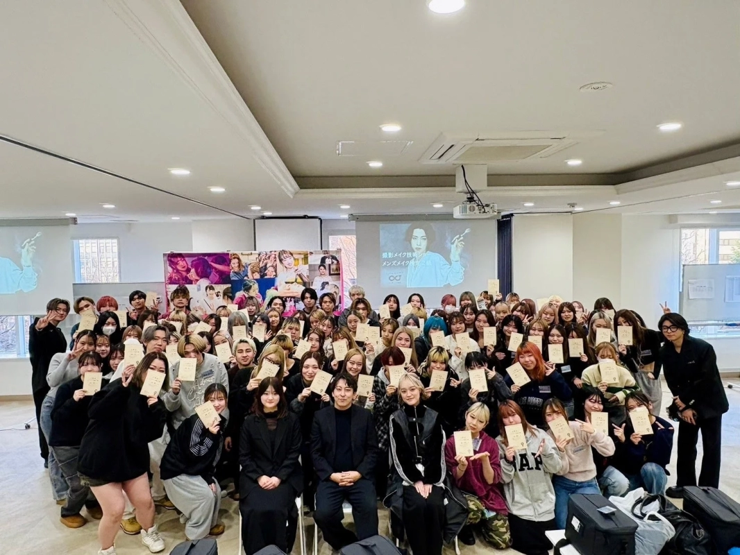 「撮影メイク技術 メンズメイク」と書かれたスクリーンを背景にした集合写真