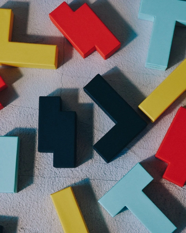 テトリスのブロックのようなカラフルなピースが散らばるデザイン