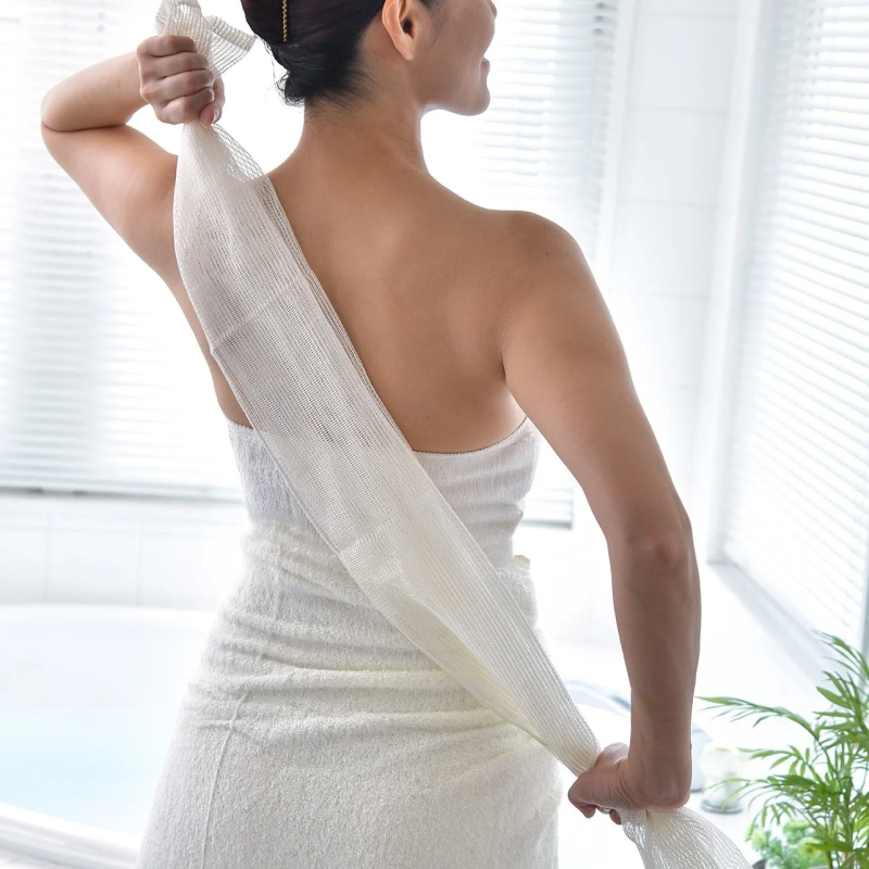 女性が背中をタオルで洗う