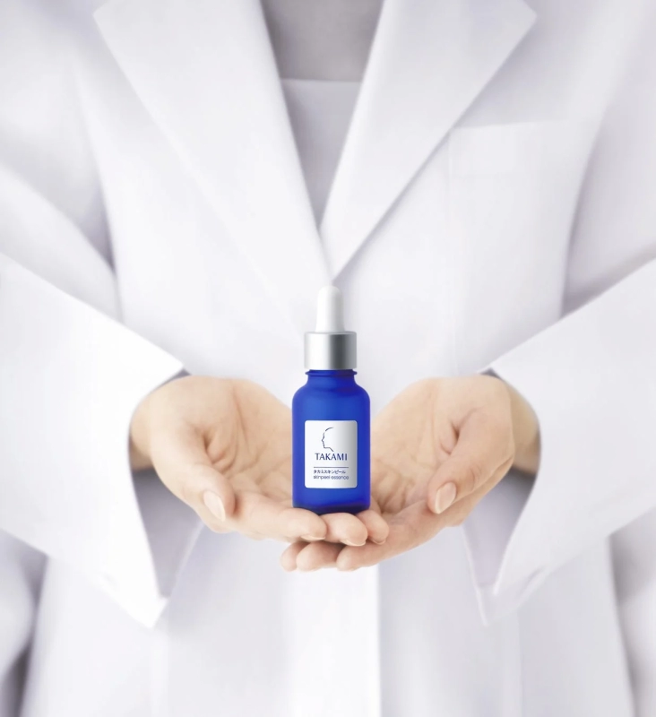 白衣を着た人物がタカミスキンピールを見せている画像