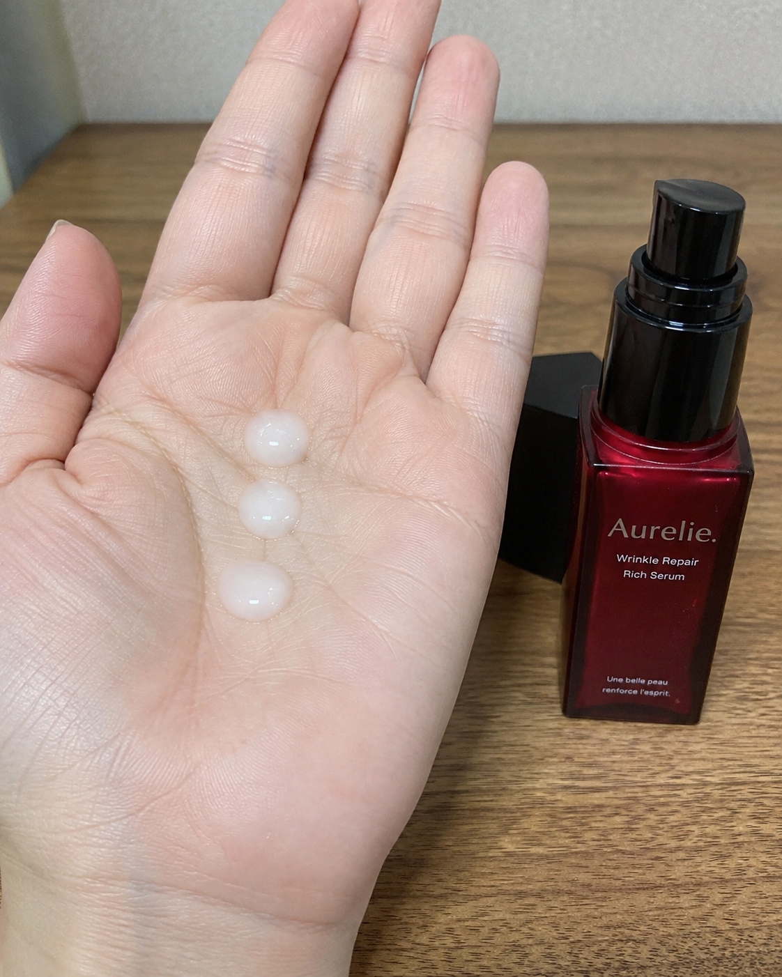 オレリー リンクルリペアセラムを手のひらに3プッシュ出した状態